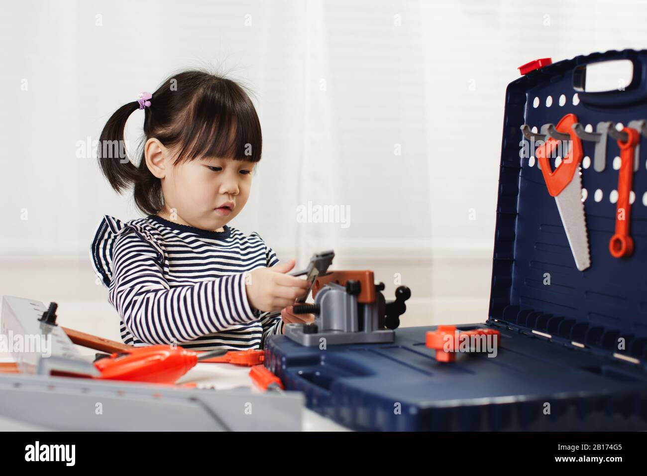 toddler girl pretend using DIY tool at home against white background ...