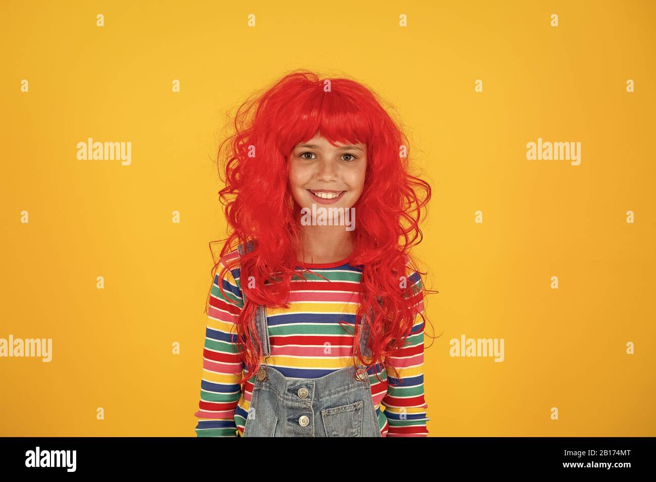 Redhead stereotypes. Redheads are not some creatures with magical soul sucking powers. Crazy redhead wig. Messy hairstyle. Kid cheerful smiling happy redhead girl. I am ginger and proud of it. Stock Photo