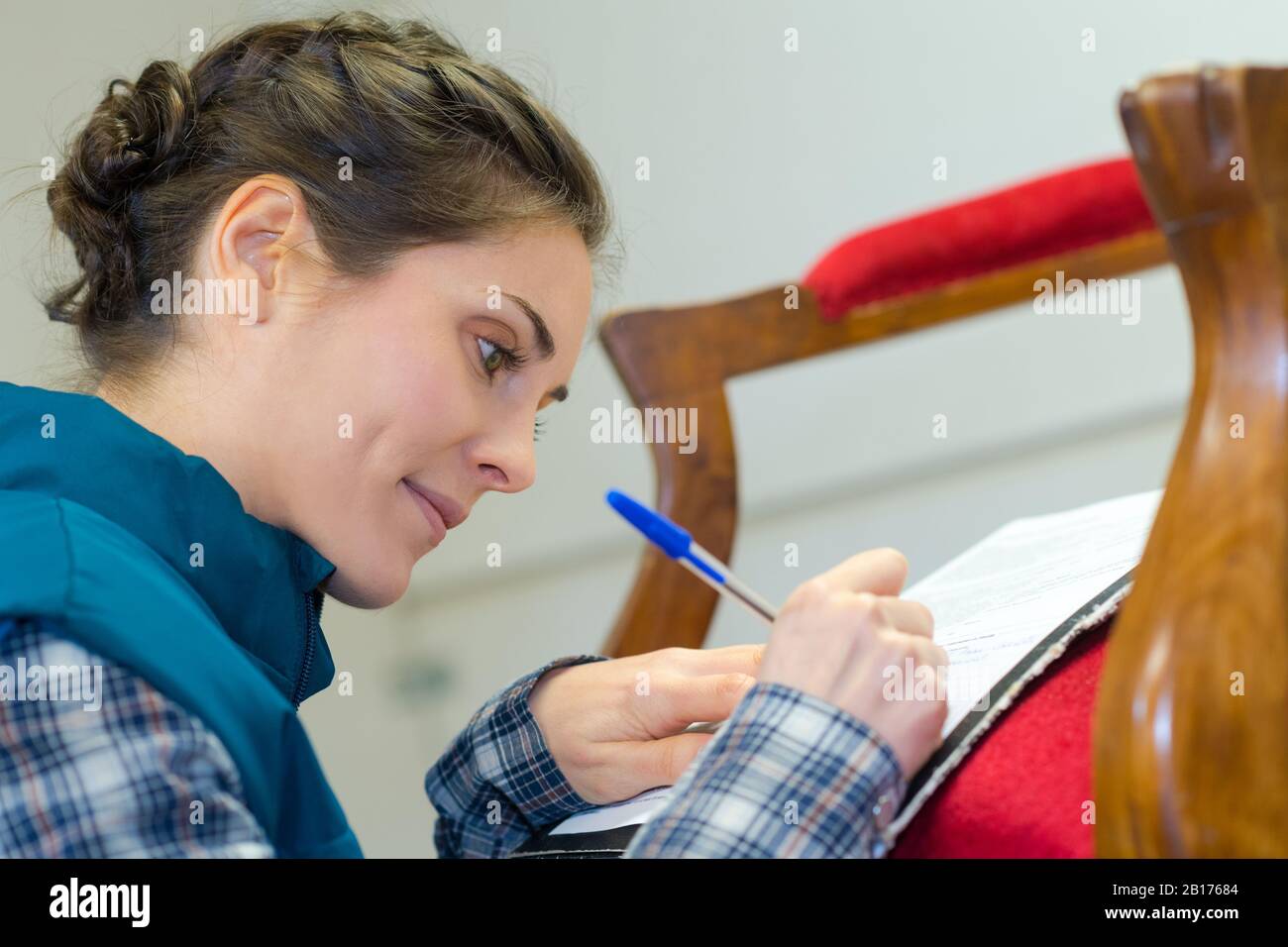 thoughtful craftswoman taking notes in the workshop Stock Photo