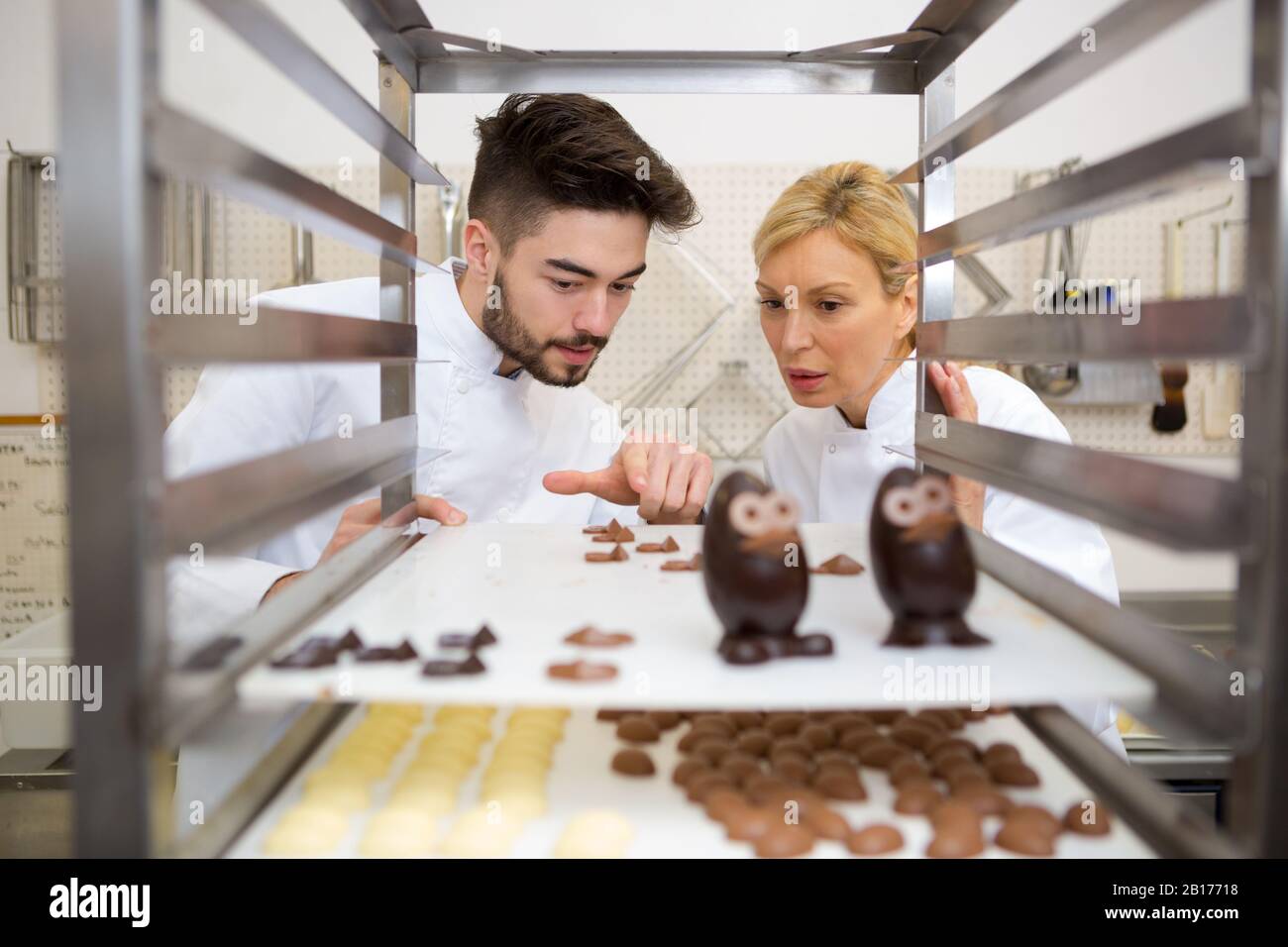 chocolatier inspecting cooled chocolates on a rack Stock Photo - Alamy