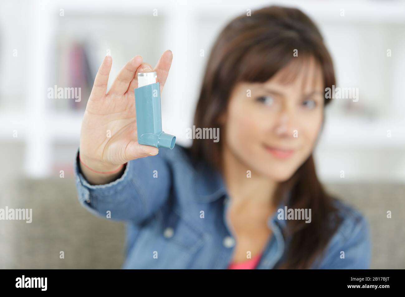 pretty woman showing an asthma inhaler Stock Photo Alamy