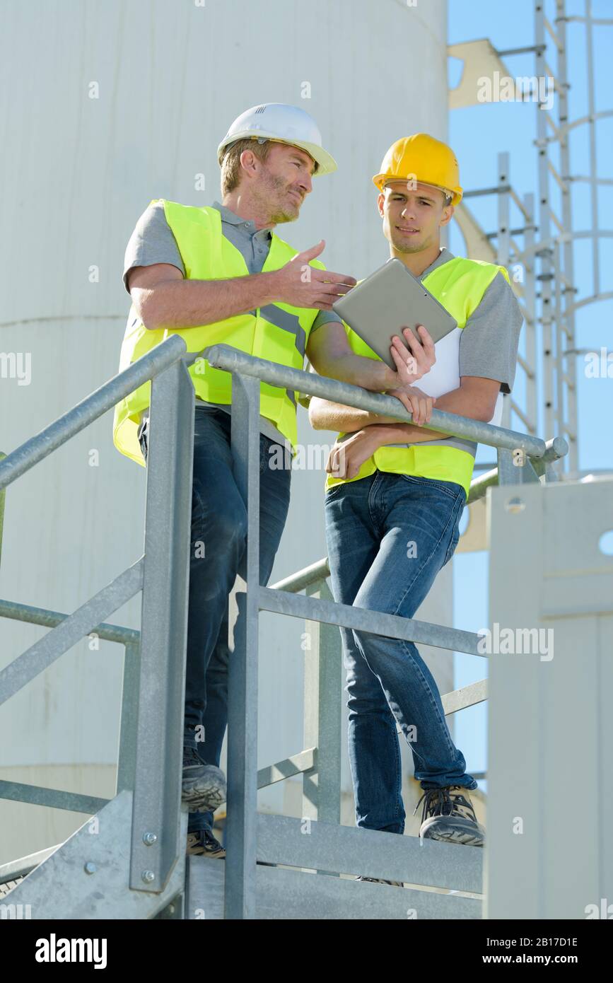 factory maintenance workers having conversation Stock Photo