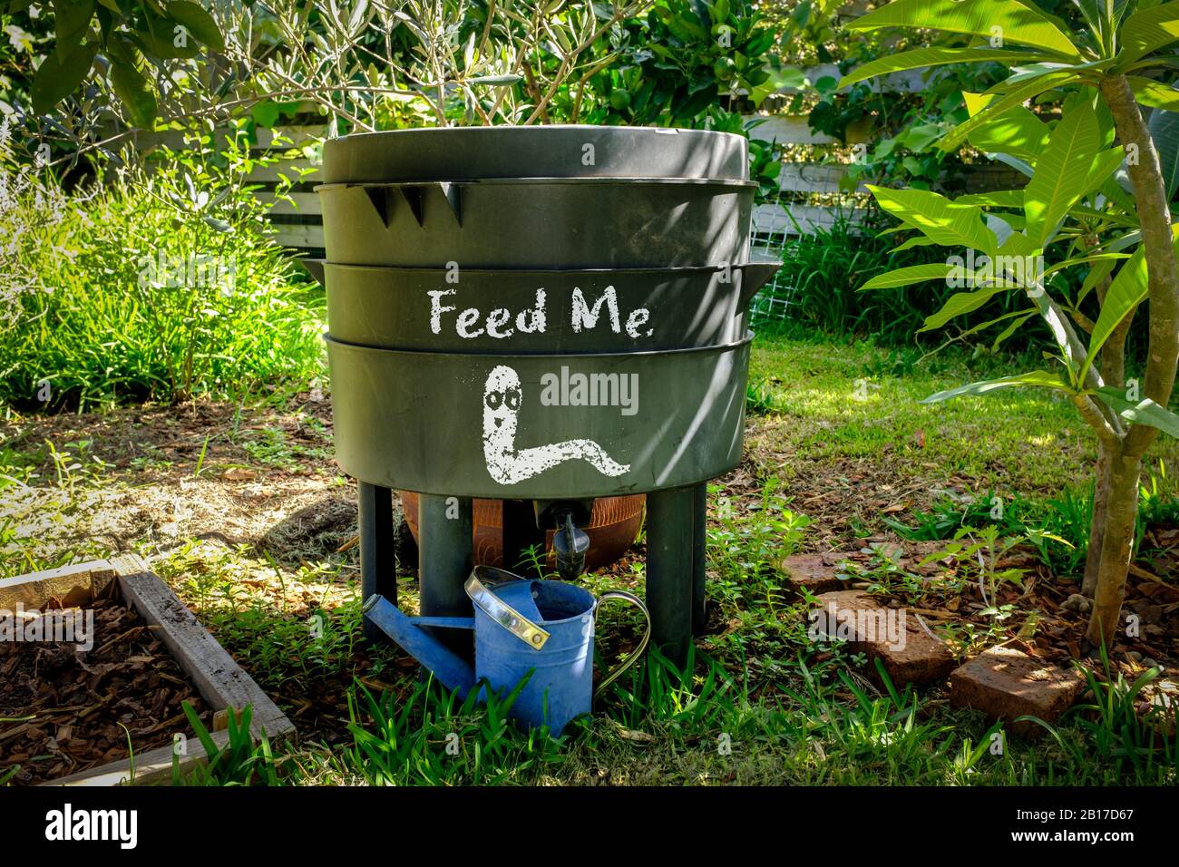 Worm farm compost bin in organic Australian garden with Feed Me worm sign, sustainable living and zero waste lifestyle Stock Photo