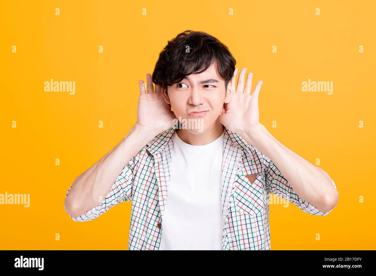 young man  with hand over ear listening and hearing Stock Photo