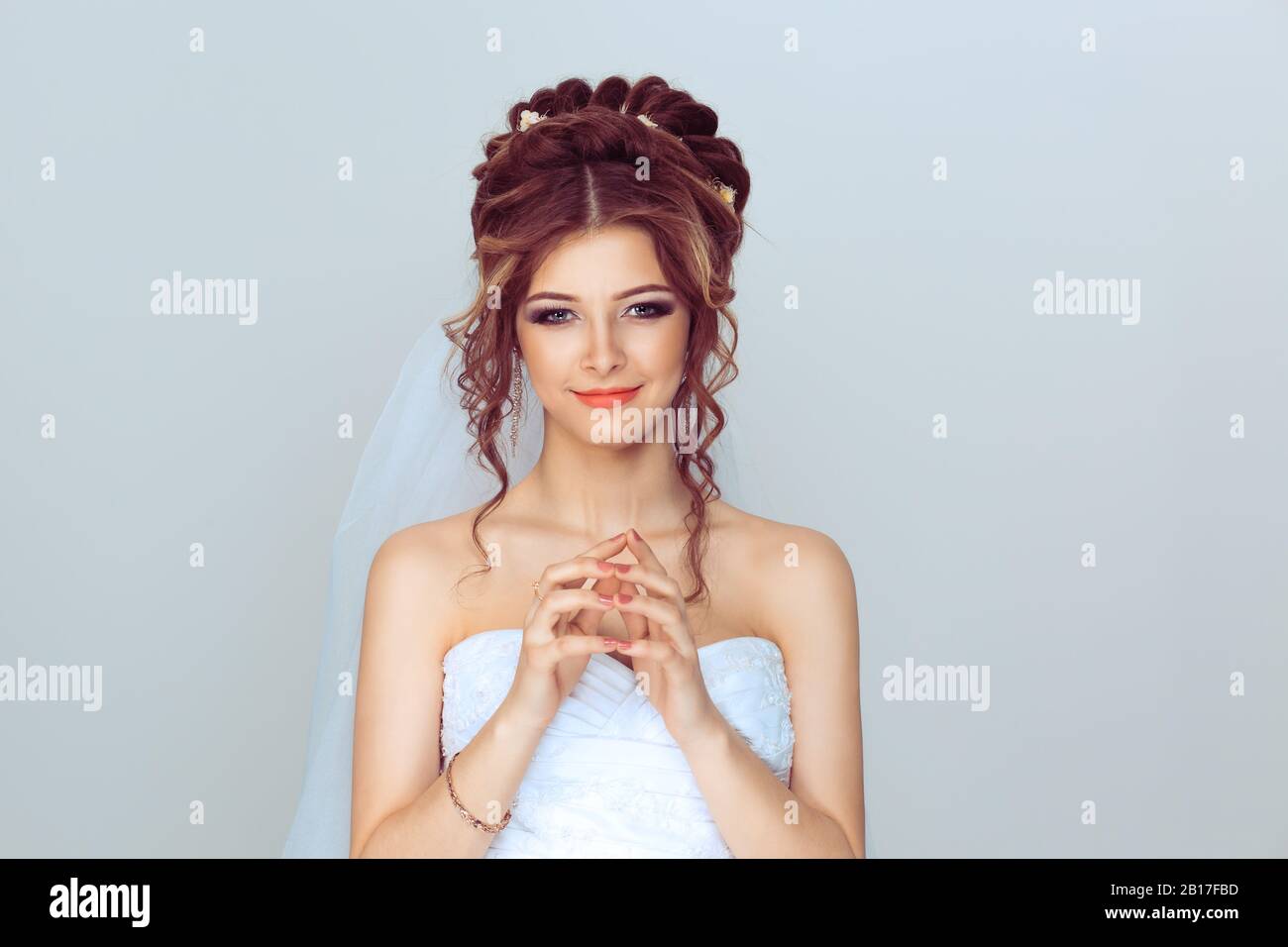 Bride plotting. Closeup portrait sneaky, sly, scheming young woman plotting revenge plan, prankster isolated on light blue wall background. Negative e Stock Photo