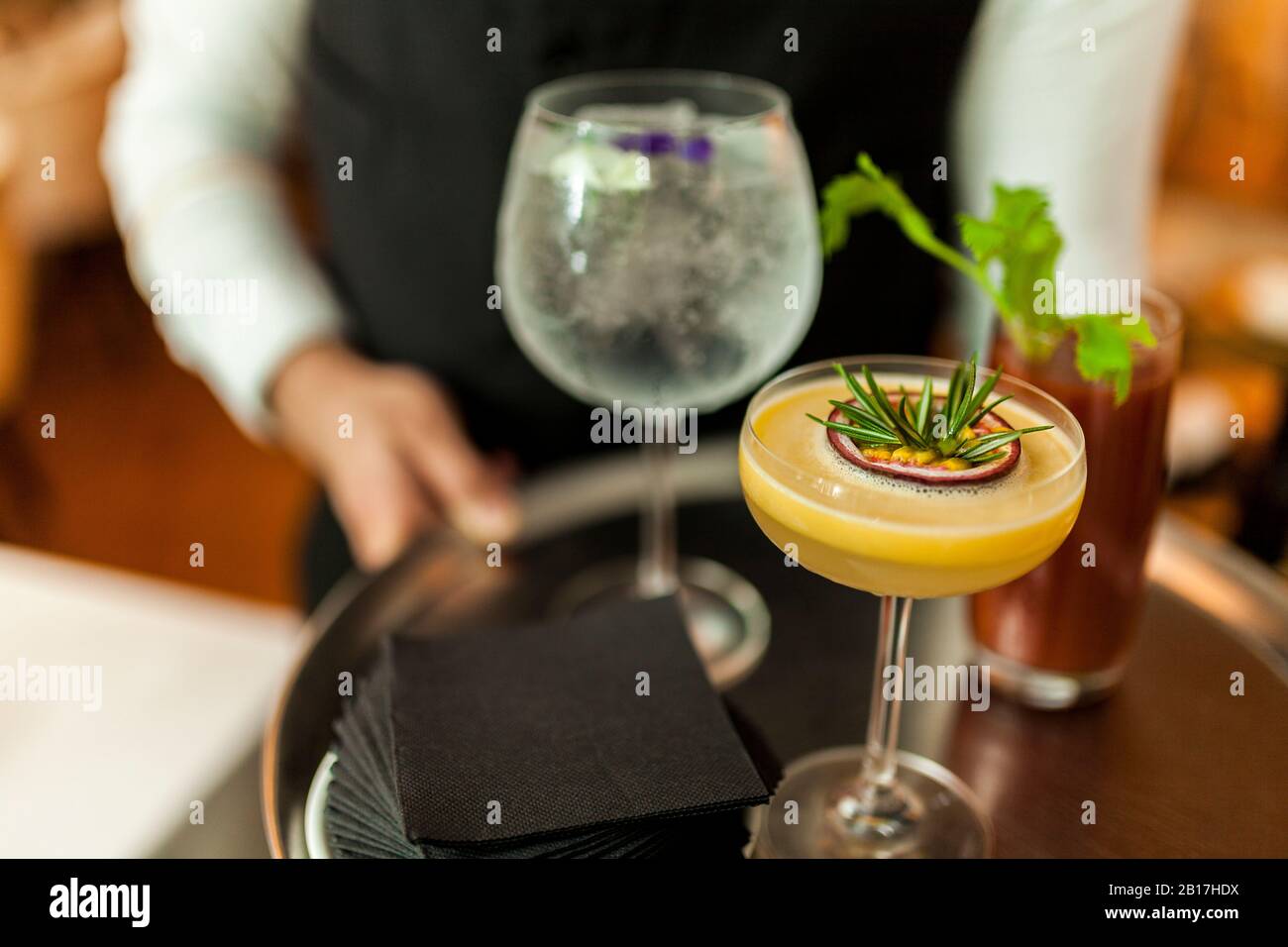 Waiter serving cocktails on silver tray Stock Photo
