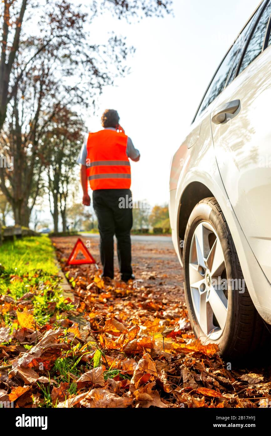 Germany, Lindenfels, Man and broken car on roadside Stock Photo