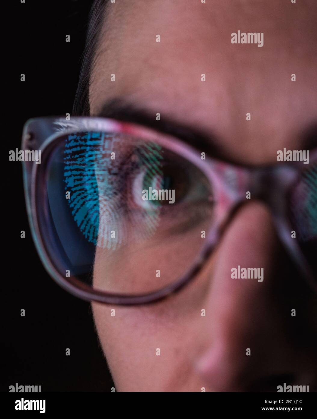 Woman with a reflection of a finger print on her glasses to represent identity and access Stock Photo