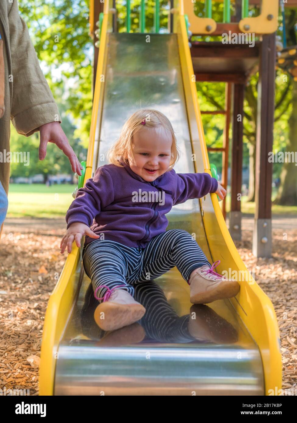 Portrait of happy toddler girl on slide at playground Stock Photo - Alamy
