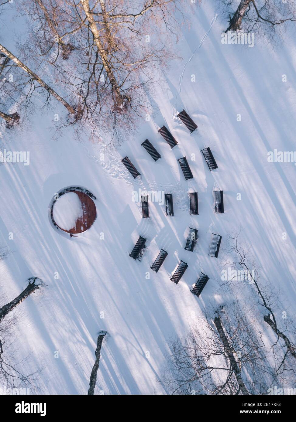 Empty benches in snow-covered park, drone view Stock Photo