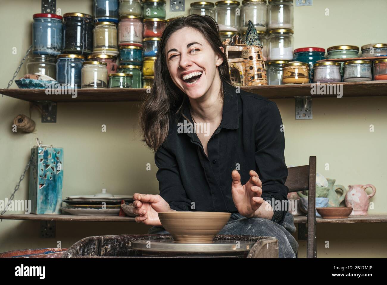Laughing woman working on workpiece in pottery Stock Photo - Alamy