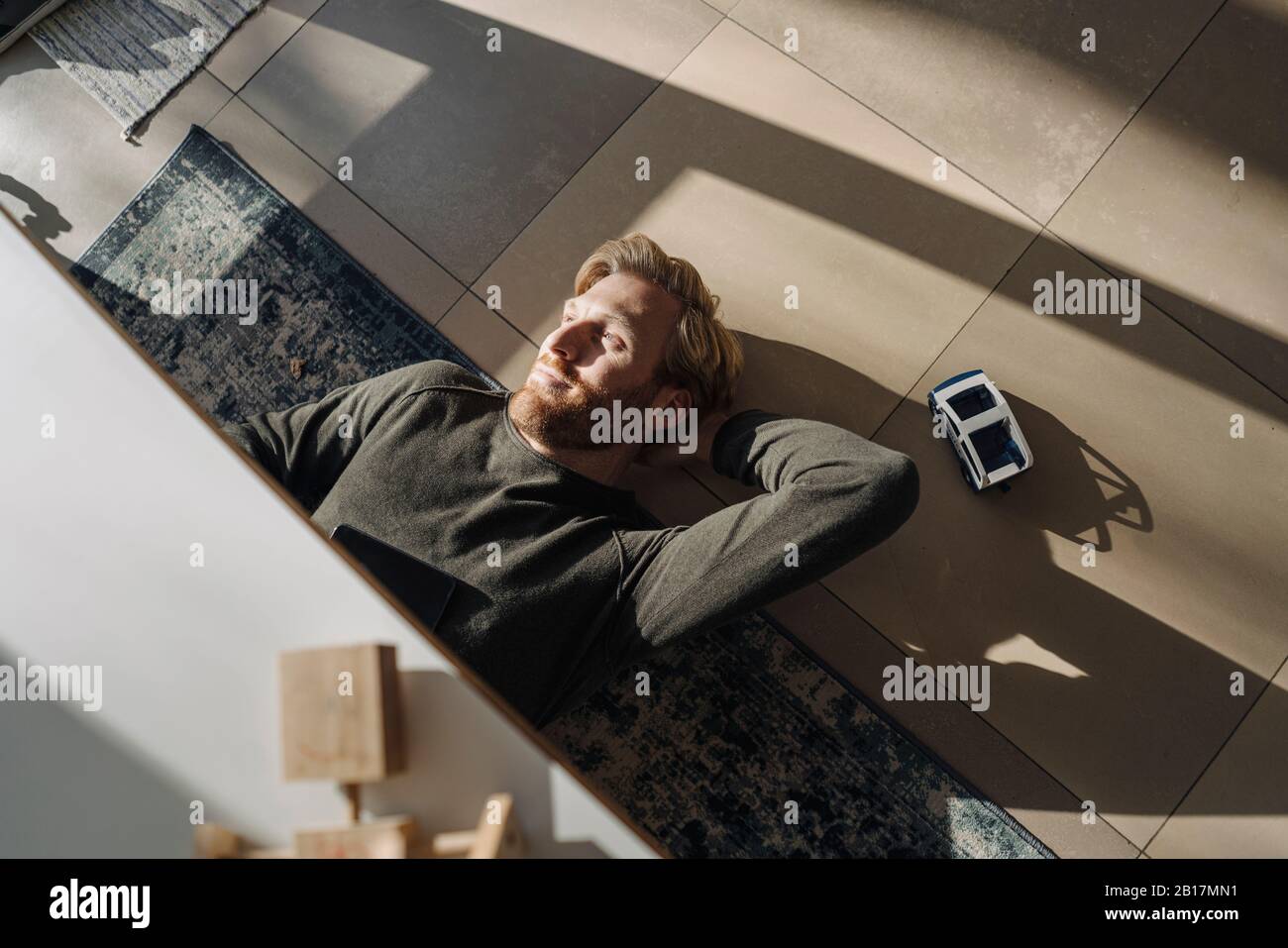 Relaxed man lying on the floor at home Stock Photo - Alamy