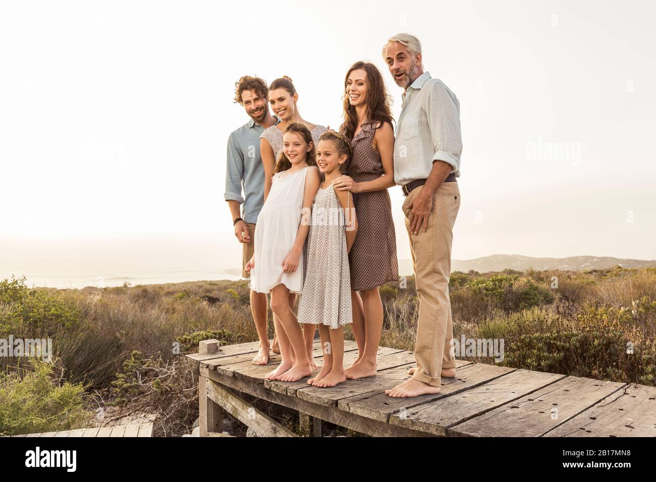 Large family enjoying the sunset standing on a boardwalk Stock Photo