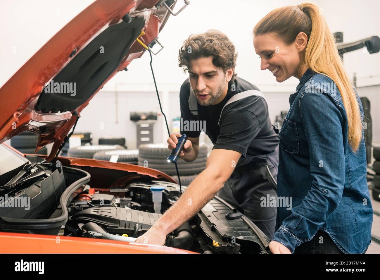Car mechanic talking to client in workshop Stock Photo