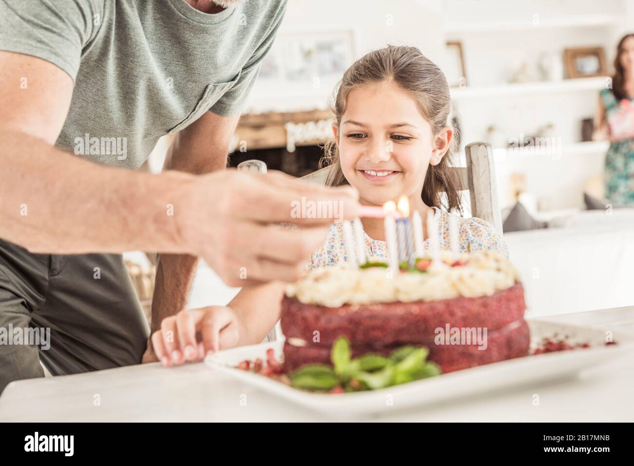 Crop view of father lighting candles on birtday cake Stock Photo
