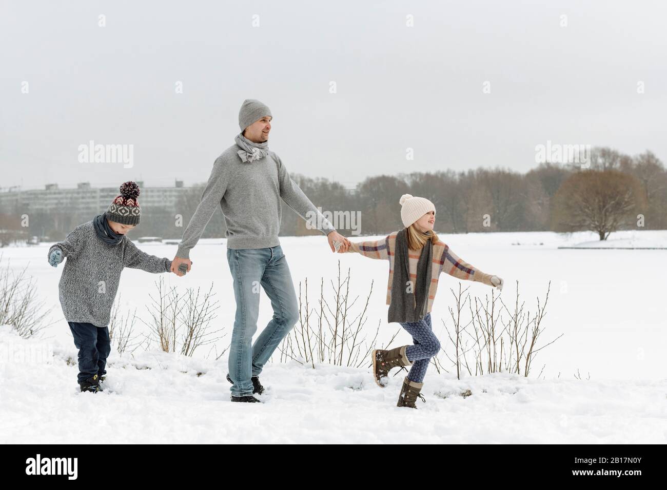 Father and two children walking in winter landscape Stock Photo
