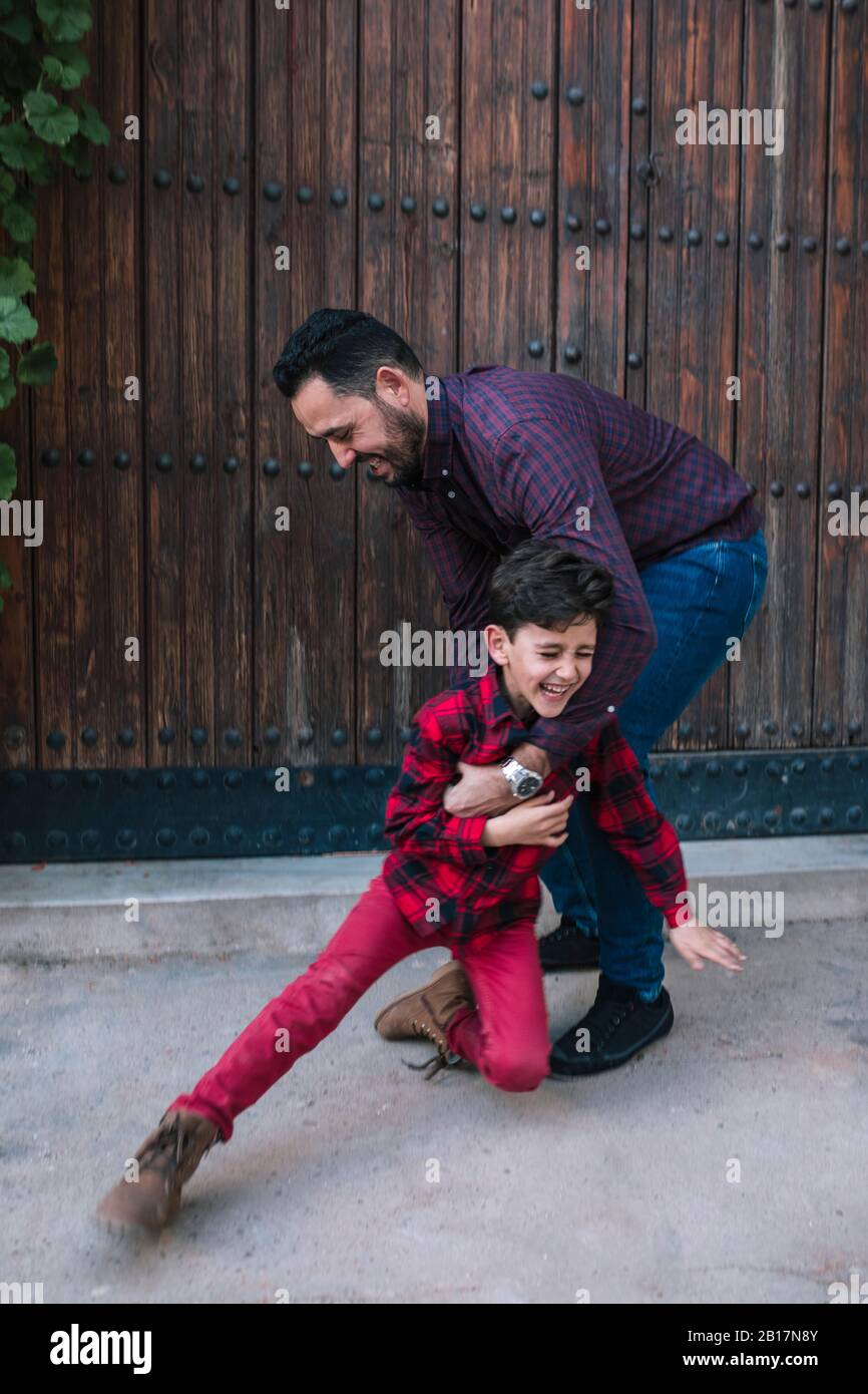 Happy carefree father playing with son outdoors Stock Photo
