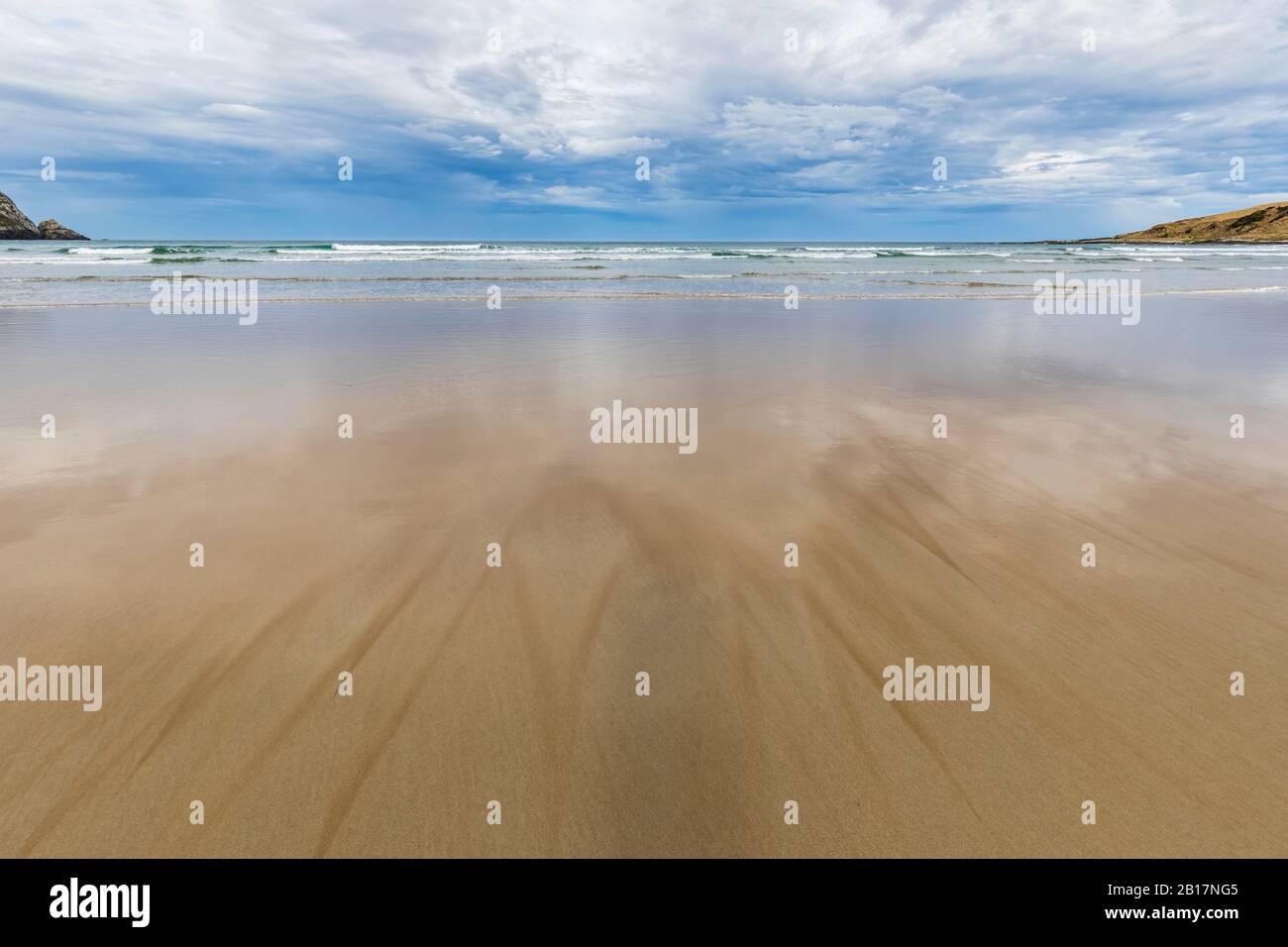 New Zealand, Cloudy sky over sandy coastal beach of Purakaunui Bay Stock Photo