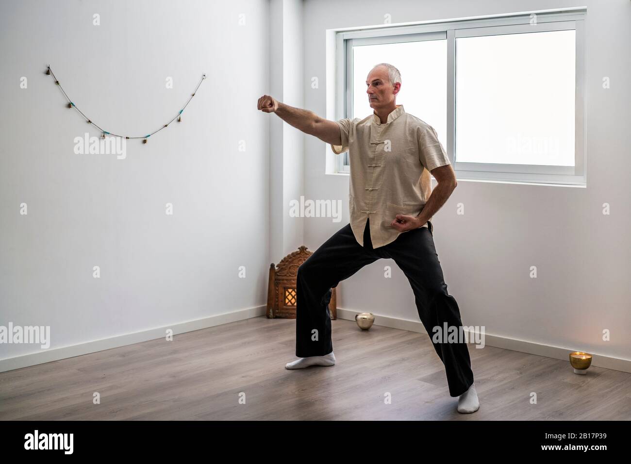 Man practicing martial arts in gym Stock Photo