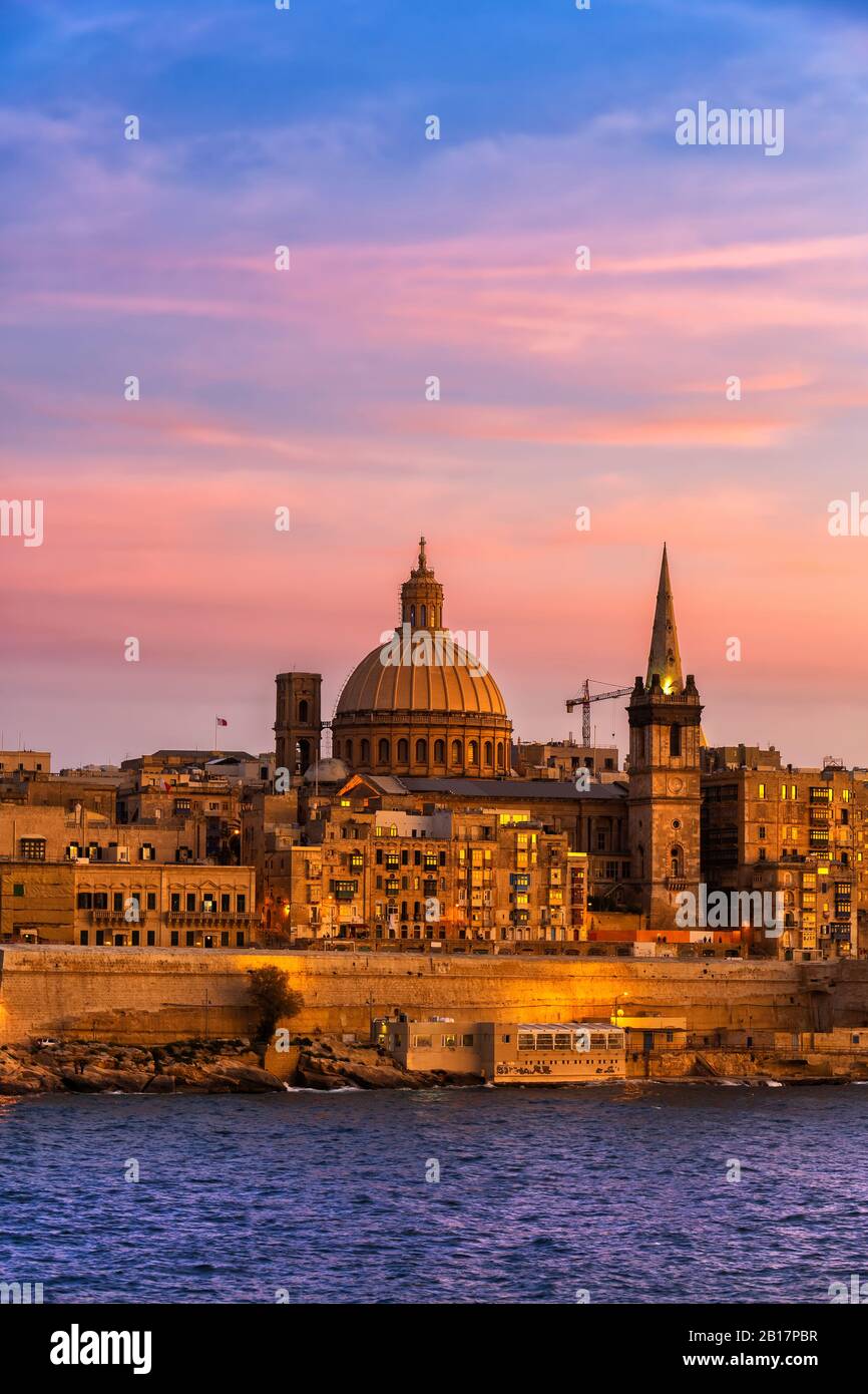 Malta, Valletta, City skyline at sunset, boats in Marsamxett Harbour in