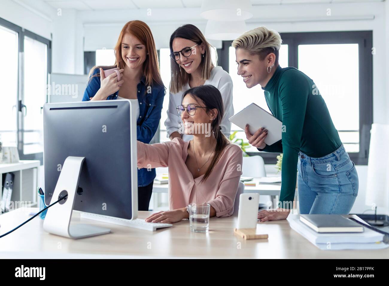 Five businesswomen using pc in an office Stock Photo - Alamy
