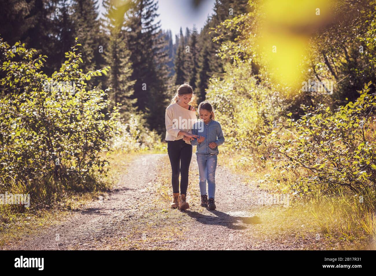 Two sisters walking on forest path Stock Photo - Alamy