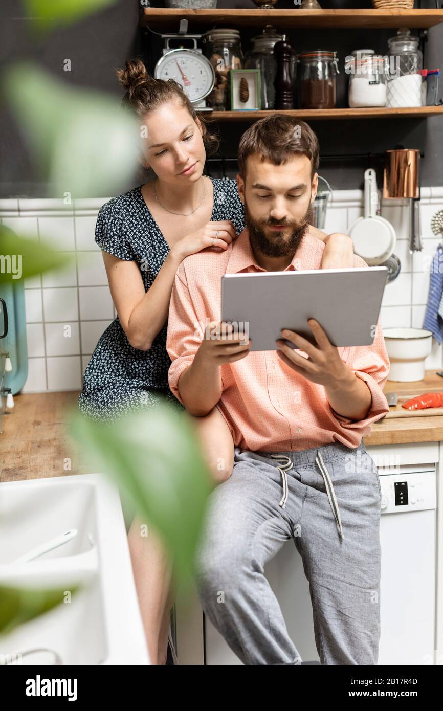 Young couple using digital tablet in kitchen Stock Photo