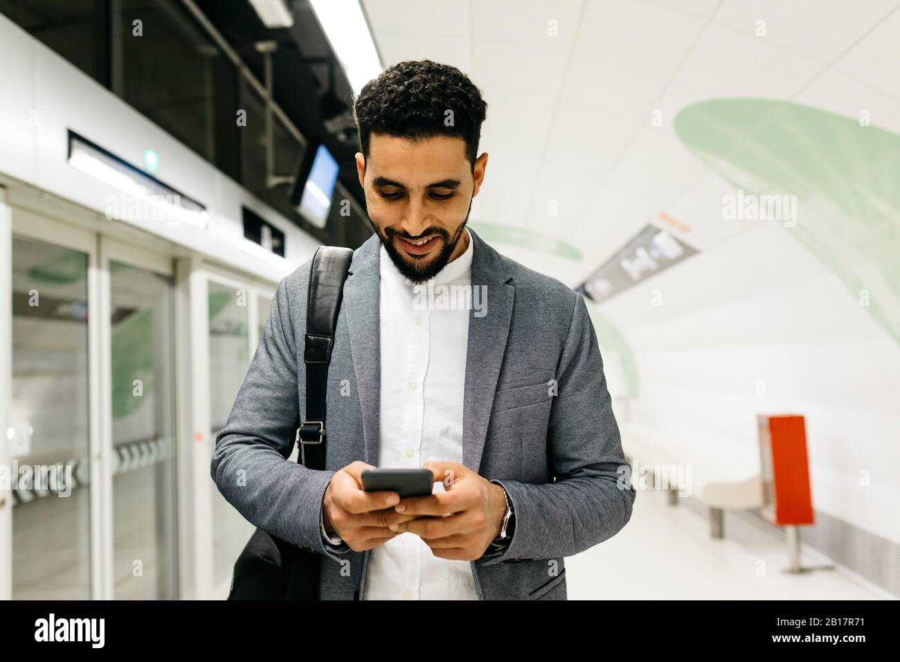 Young businessman using cell phone in subway station Stock Photo