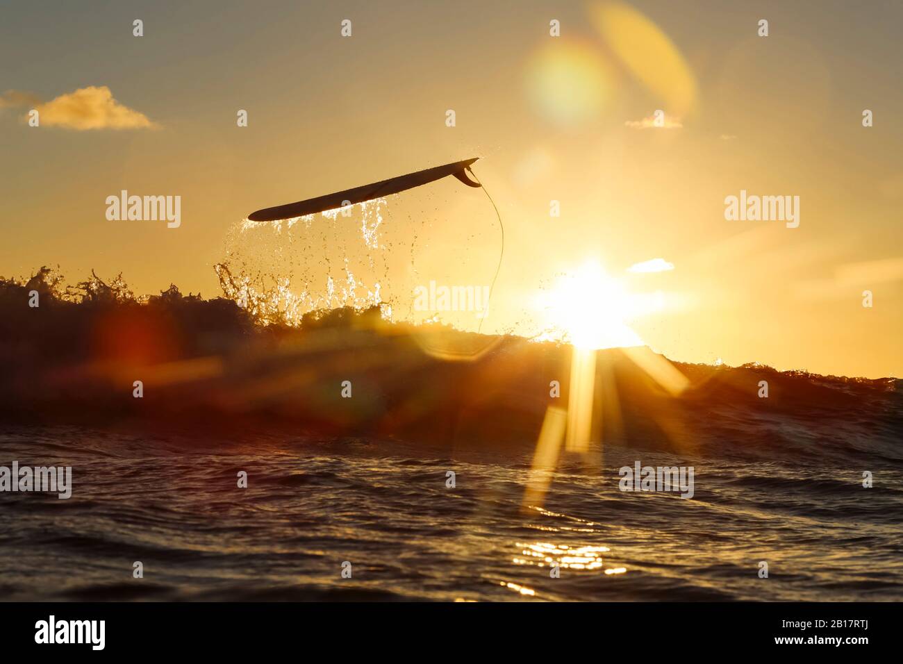 Indonesia, Bali, Surfboard above sea wave at sunset Stock Photo Alamy