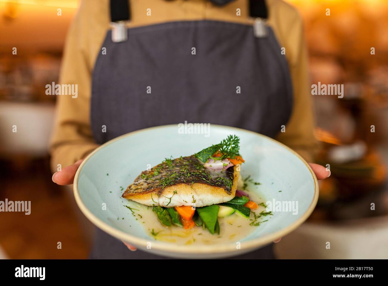 Waitress serving healthy fish and veggies Stock Photo
