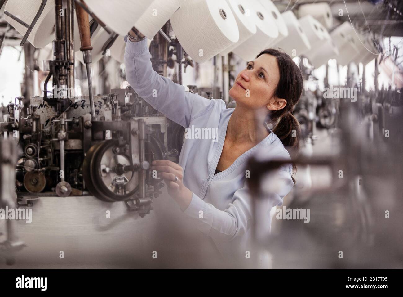 Woman checking cotton reel in a textile factory Stock Photo