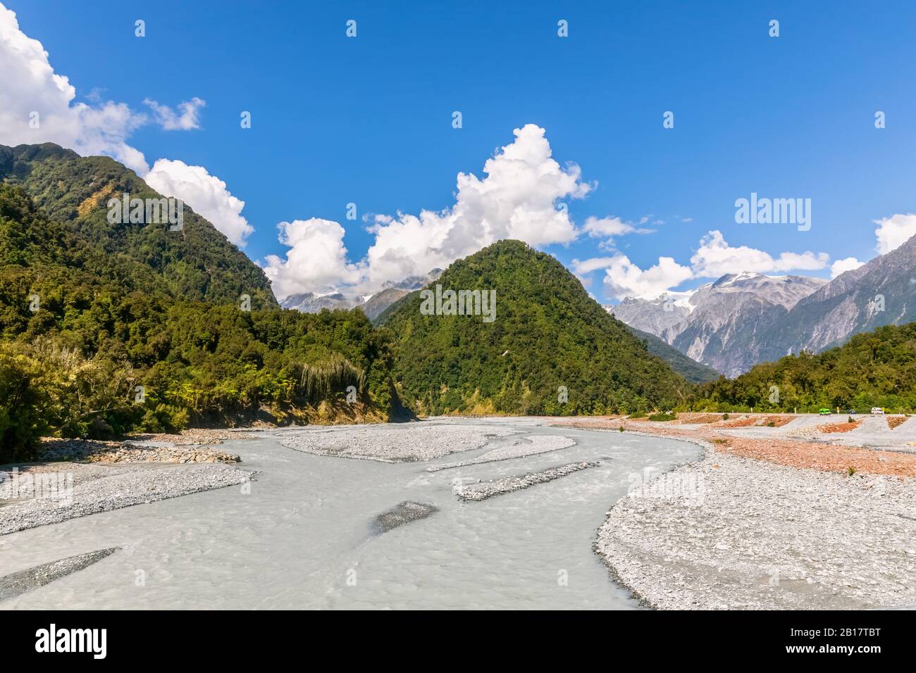 New Zealand, Westland District, Franz Josef, Scenic view of Waiho River with forested mountains in background Stock Photo