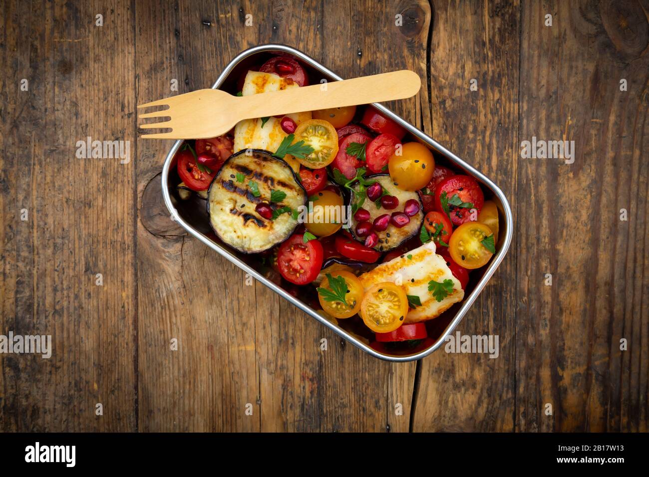 Lunch box with tomato salad with grilled vegetables and halloumi cheese, pomegranate seeds