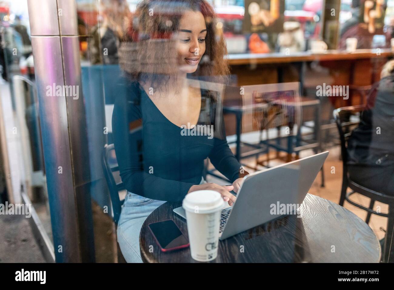 Young woman using laptop in a cafe Stock Photo