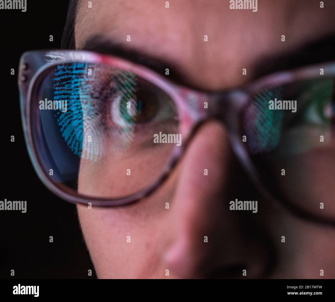 Woman with a reflection of a finger print on her glasses to represent identity and access Stock Photo
