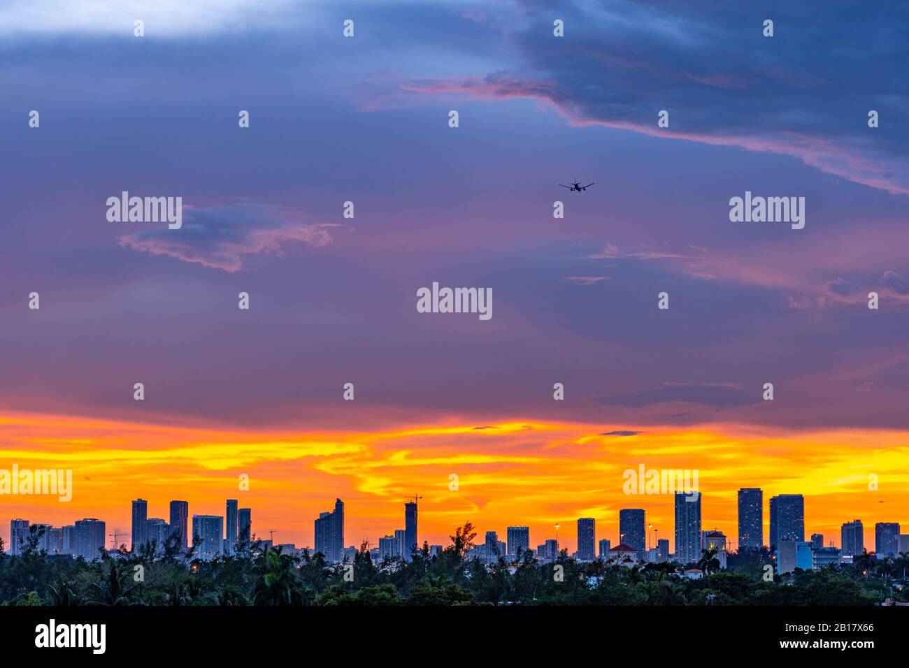 Plane landing over Miami city at sunset Stock Photo