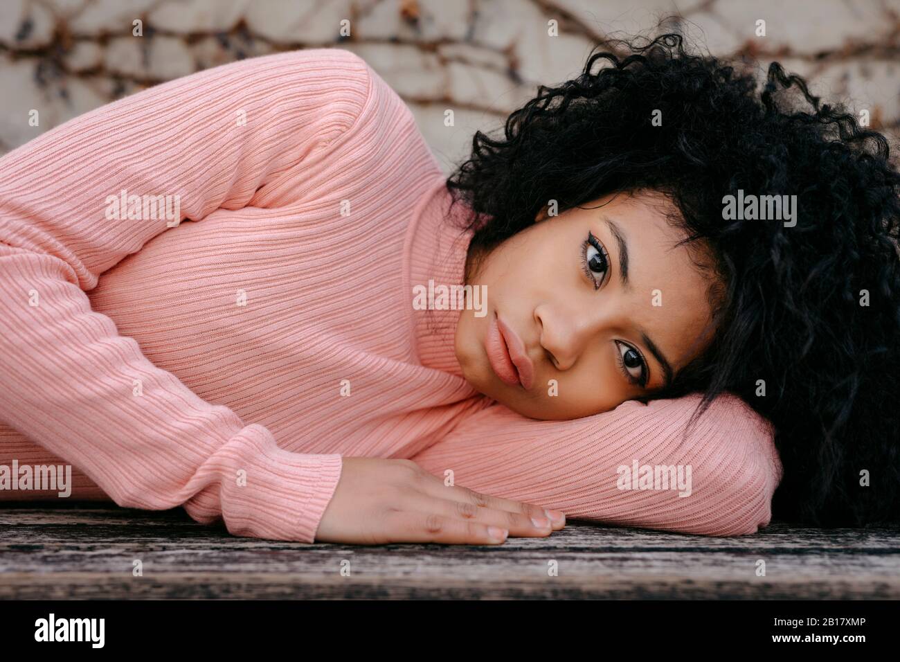 Portrait of a beautiful young woman lying on a bench Stock Photo