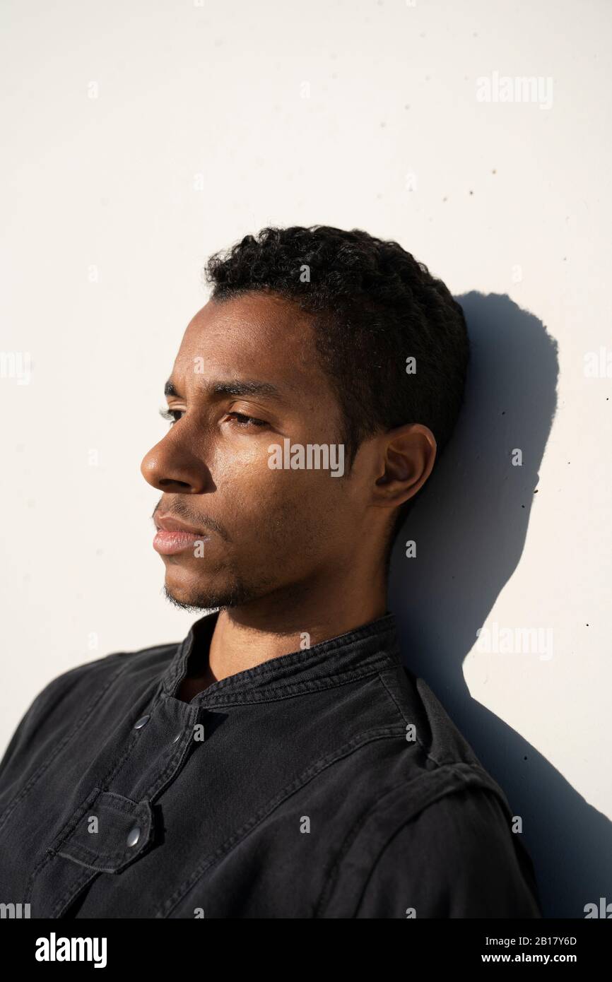 Portait of a young man leaning against a concrete wall outdoors Stock ...
