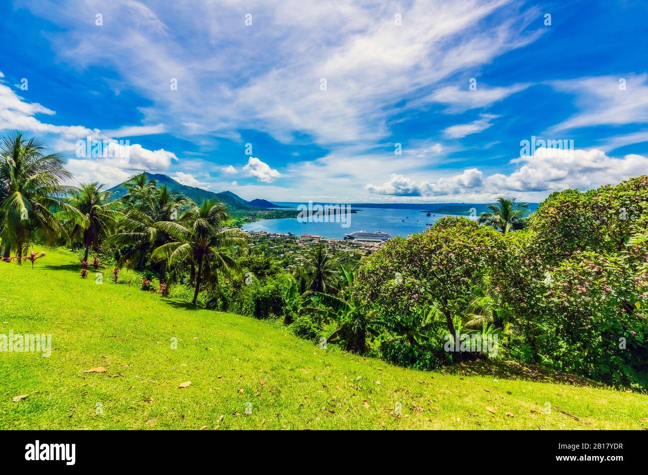 Papua New Guinea, East New Britain Province, Rabaul, Clouds over palm trees growing on green hillside of New Britain island Stock Photo