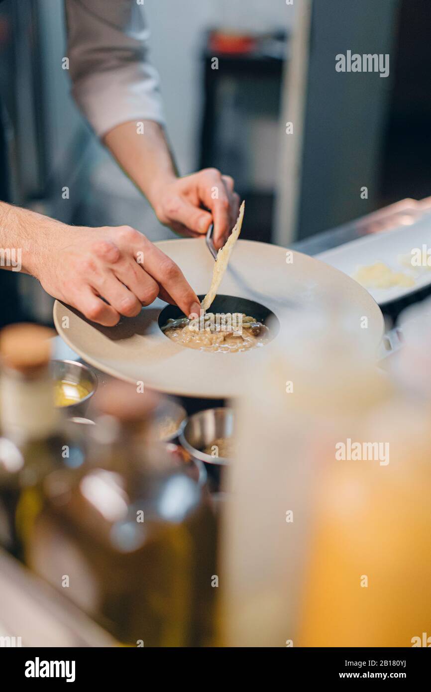 Chef preparing a dish with cheese in an Italian restaurant Stock Photo