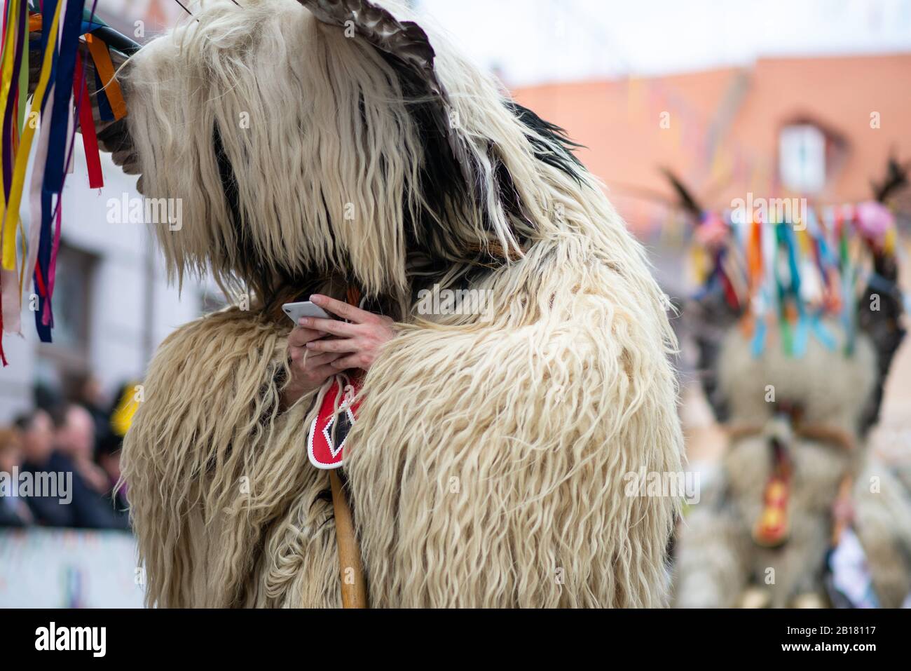 A man dressed as traditional Slovenian ethnographic character Kurent uses his phone during the Kurentovanje 60th International Carnival Festival.Kurentovanje is Slovenia's main spring cultural and ethnographic festival of national importance, the richest international Pustovanje (Shrovetide celebration) in the land. The unique Ptuj carnival legacy, which is deeply rooted in the mystical pagan character of Kurent and many other characters, is combined with attractive local features throughout the festival, such as music, dance, fashionable local cuisine and high quality wines. In the midst of a Stock Photo