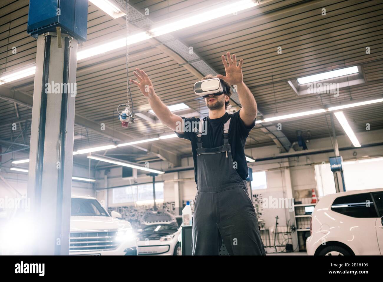 Car mechanic wearing VR glasses in a workshop Stock Photo