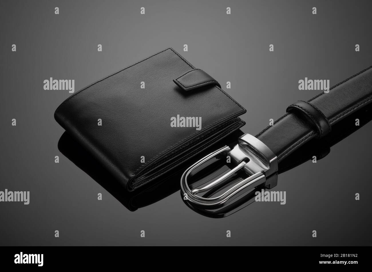 Fashionable leather men's wallet and belt on a black background Stock Photo