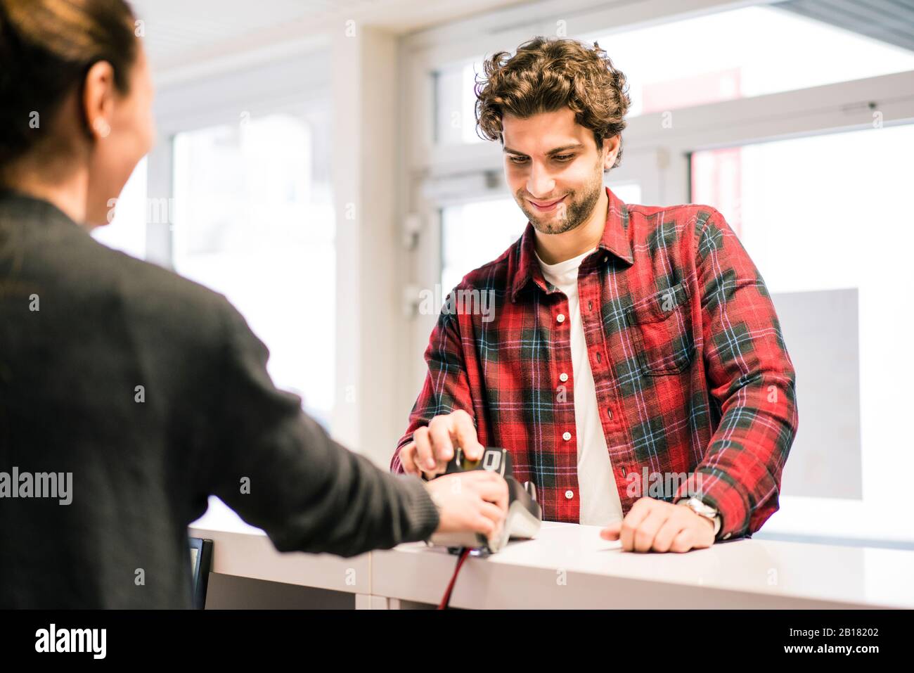 Man paying with credit card at the counter of a shop Stock Photo