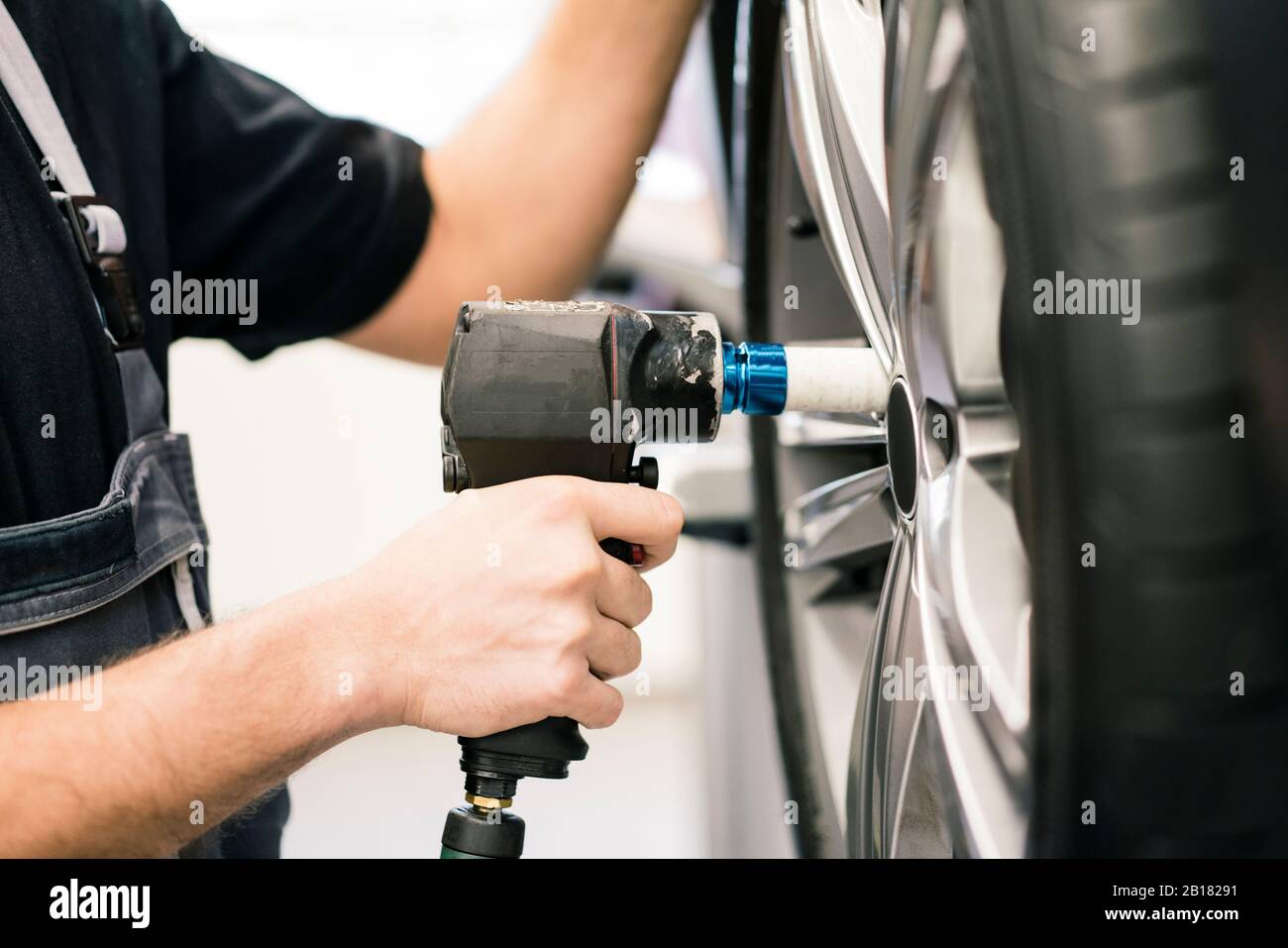 Close-up of car mechanic in a workshop changing tire Stock Photo