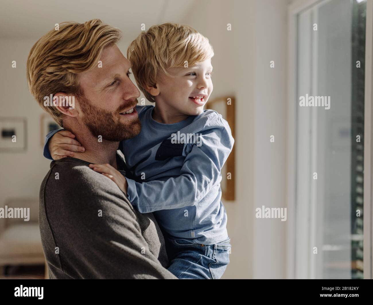 Happy father carrying son at home Stock Photo