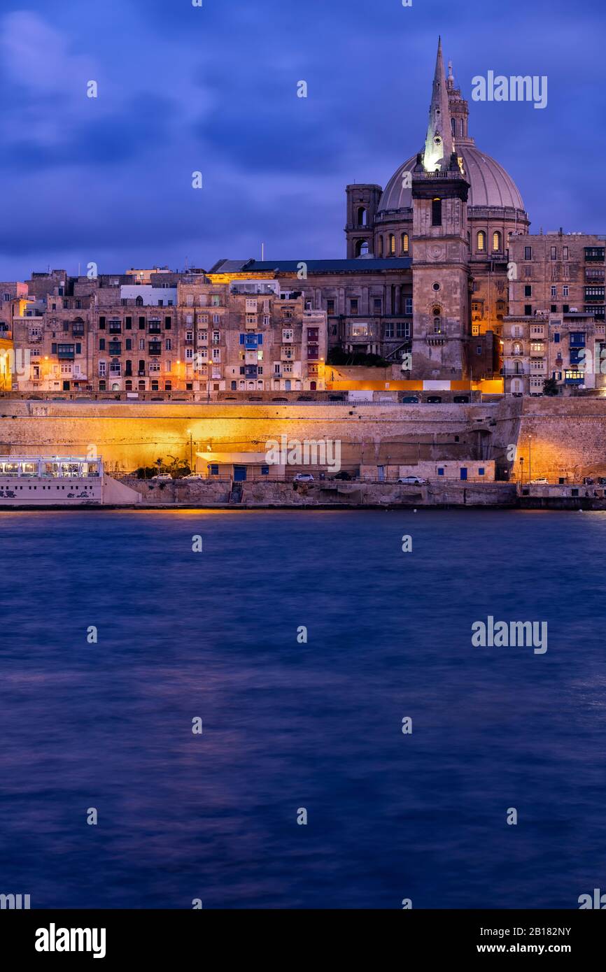 Malta, Valletta, Old town illuminated at night seen across water Stock Photo