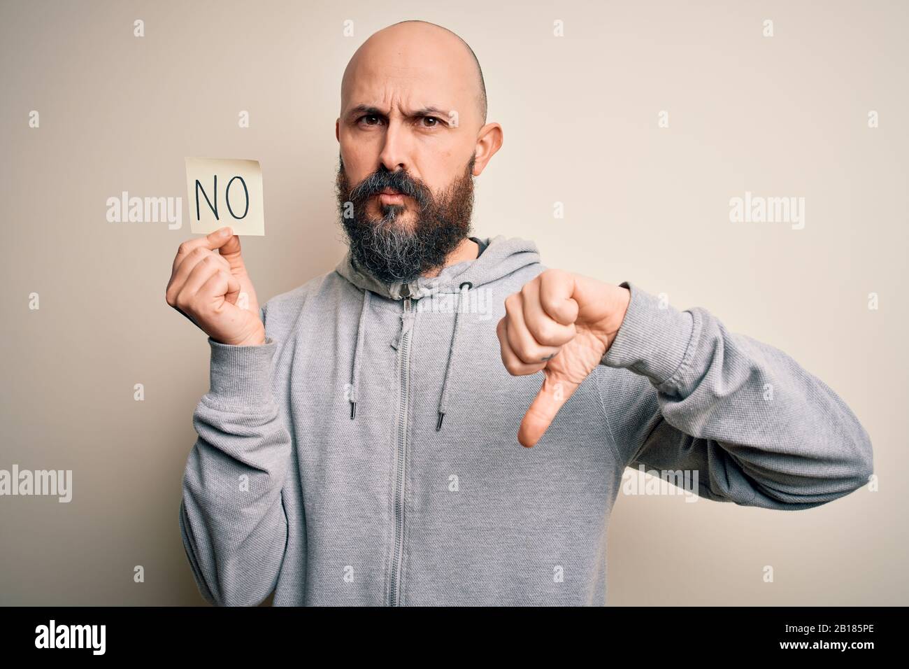 Handsome bald man with beard holding reminder paper with negative ...