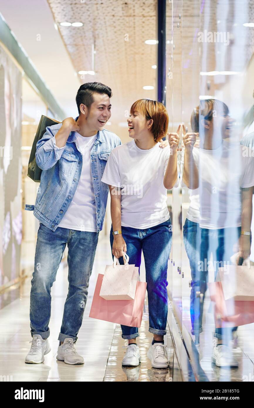 Young Vietnamese couple in casual clothes laughing at some ridiculous