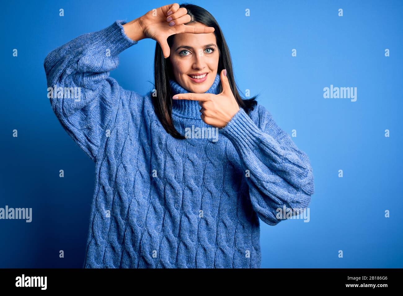 Young brunette woman with blue eyes wearing casual turtleneck sweater ...